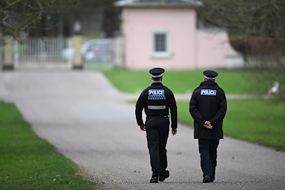 Police officers approach the gates of Royal Lodge, Andrew’s former home.