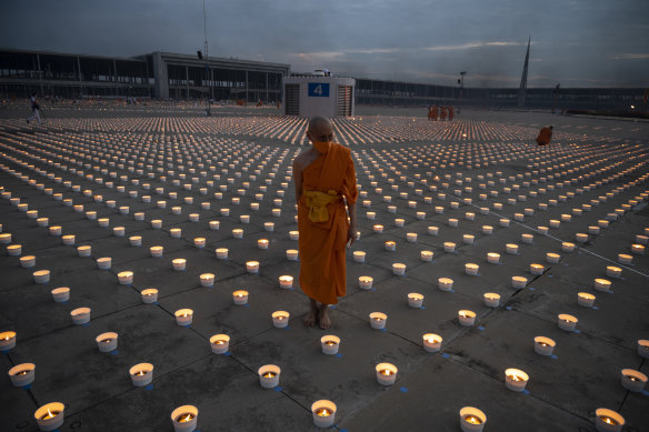 Buddhist novice monks light 180,000 candles during Vesak Day celebration at Wat Phra Dhammakaya temple on the outskirts of Bankok on Wednesday. Devotees had to attend the ceremony via Zoom this year because of COVID-19.