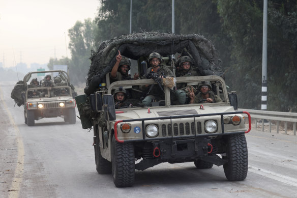 Israeli soldiers patrol a road near the border fence with Gaza on October 10, 2023.