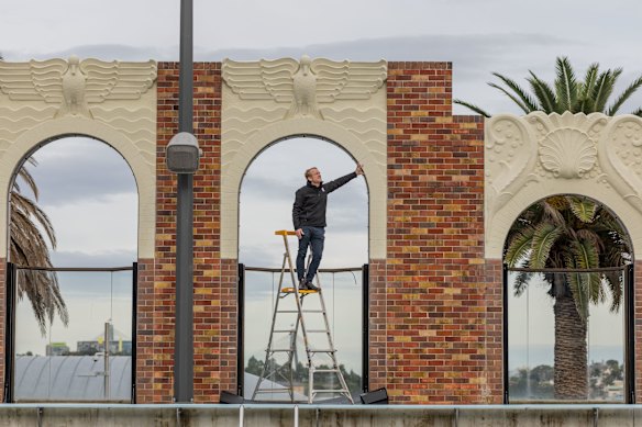 Traditional Restoration Company managing director James Ginter inspects the restored art deco wall at the pool.