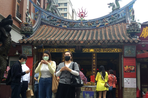 People visit a temple in Taipei, Taiwan, on Monday. The island managed the pandemic without lockdowns.