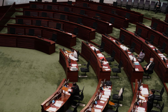 Empty seats of pro-democracy legislators, top, are seen at the Legislative Chamber in Hong Kong after they resigned en masse last year.