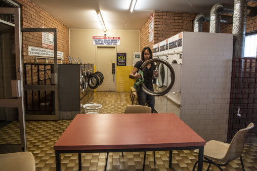 Katrina White cleans her empty Laundromat in Narooma.