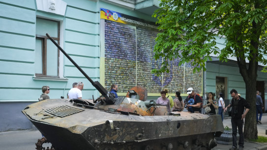 People look at a Russian military vehicle destroyed by the Ukrainian troops in a battle against the Russian invaders and taken to the capital as a reminder of war in Kyiv.