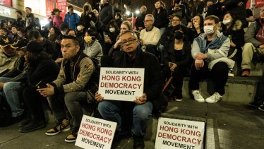 Protesters hold pro-Hong Kong signs at the 'Stand With Hong Kong' rally at Martin Place on Friday night.