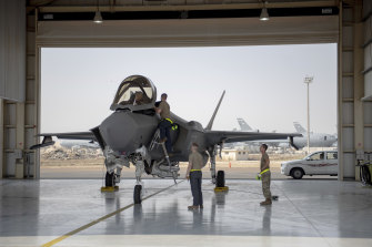 A US Air Force F-35 fighter jet pilot and crew prepare for a mission at Al-Dhafra Air Base in the United Arab Emirates. 