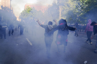 Demonstrators hold up their arms in front of a line of police officers during a protest for the death of George Floyd near the White House on Monday.