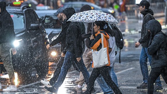 Caught in the rain: Pedestrians on Bourke Street.