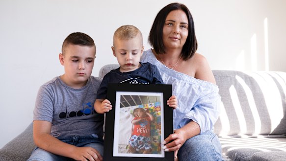 Elizabeth Miroforidis with her sons Romeo and Alex Kakias holding a photo of their brother Elias, who died.