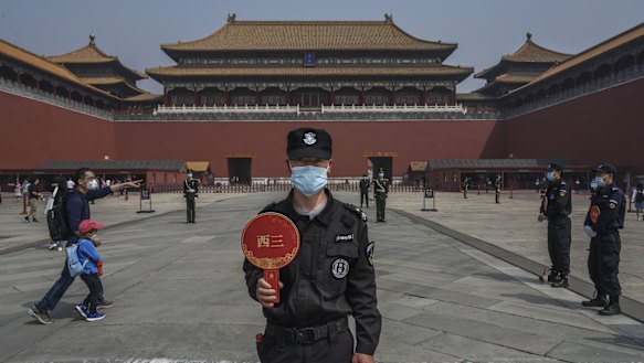 A Chinese guard wears a protective mask as he stands at the entrance to Beijing's Forbidden City. 