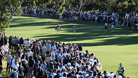 Cameron Smith walks down the 18th fairway in front of massive crowds at Grange Golf Club.