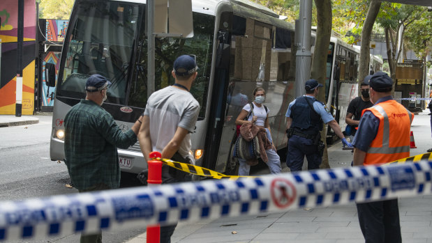 Overseas arrivals outside the Sydney Marriott Hotel. NSW Health says a quarantine hotel guard likely caught COVID-19 from a returned US traveller.