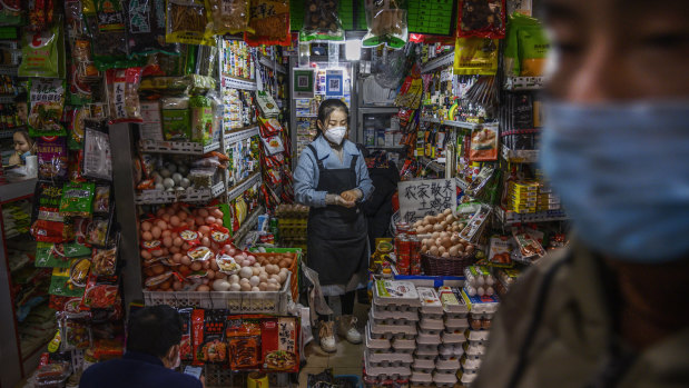 Chinese shopkeeper waits for customers at a local market in Beijing.