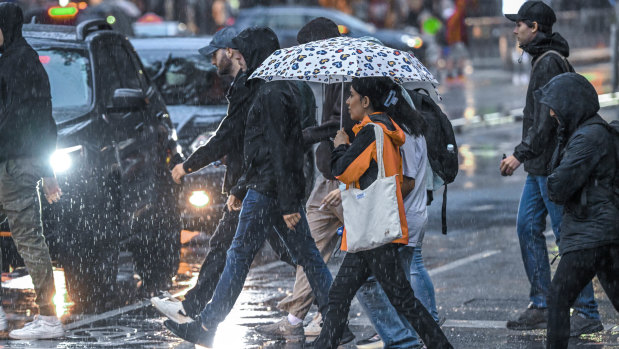 Caught in the rain: Pedestrians on Bourke Street.