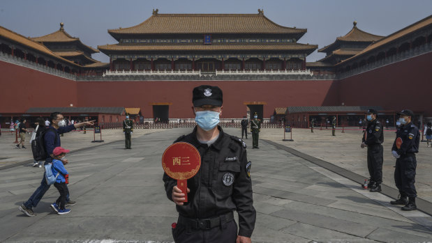 A Chinese guard wears a protective mask as he stands at the entrance to Beijing's Forbidden City. 