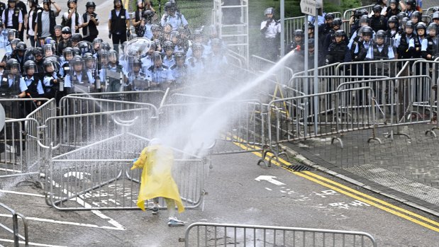 Police officers use a water cannon on a lone protester near the government headquarters in Hong Kong on Wednesday.