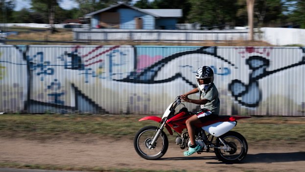 A child rides a motorbike through Cooie Park in Moree, where youth crime has become a significant problem.