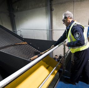 Deputy chief police officer Mark Walters destroys weapons in ACT Policing's new shredder earlier this month.