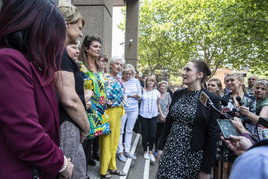 Lawyer Rebecca Jancauskas standing with a group of women who were involved in the class action.