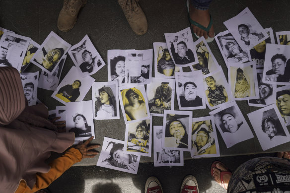 People looking for their relatives inspect photographs of soccer riot victims provided by volunteers to help them identify their family members in Malang, East Java.