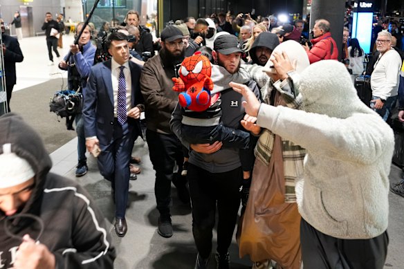 A group of supporters surround an Islamic State-linked family as they arrive at Melbourne Airport on May 7.