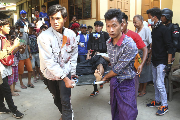 An injured man is carry away after security forces dispersed an anti-coup demonstration in Mandalay, Myanmar on Saturday.