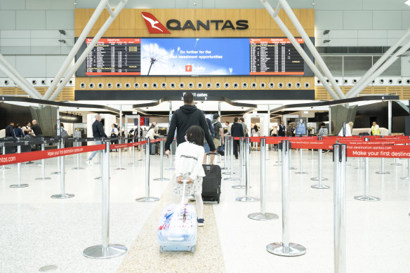 A domestic traveller checks into a Qantas flight from Sydney Airport on Thursday’s National Day of Mourning. 