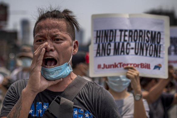 Protesters wearing masks hold up placards as they protest the anti-terror bill in Quezon city, Philippines, on Wednesday.