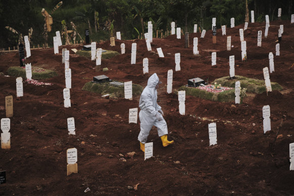 A municipal cemetery worker walks through  a special cemetery for suspected  Covid-19 victims in Jakarta, Indonesia.