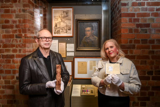 Murray Griffin jnr with the sculpture that artist Murray Griffin carved from a chair leg, and Kate Griffin with his war artist permit.