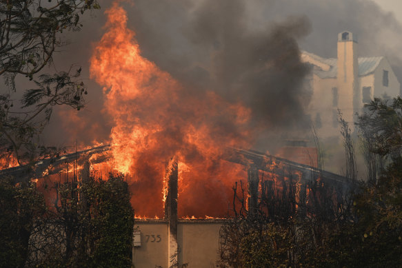 Fire ravages a home amid high winds in the Pacific Palisades, Los Angeles.