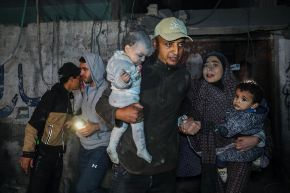 Palestinians are evacuated from a building hit by Israeli air strikes in Rafah, Gaza.