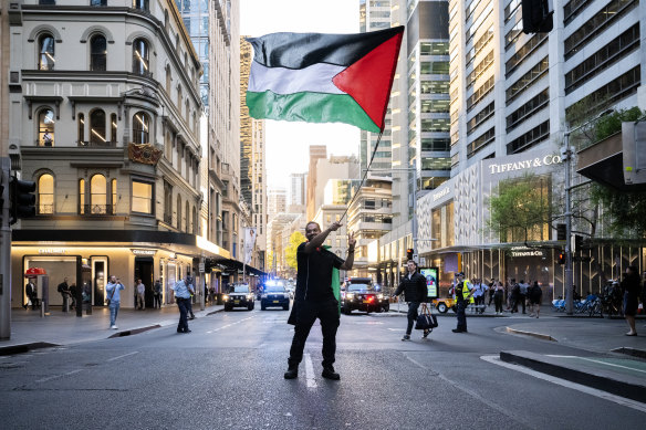 A protester waves the Palestinian flag at a rally in central Sydney.