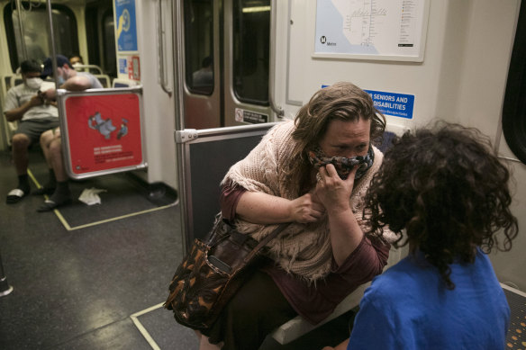 A commuter talks to her son on the train in Los Angeles on Monday.
