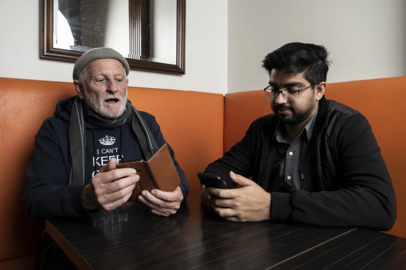 Salman Roubil, right, takes Glenn Massicks through how to use his smartphone.