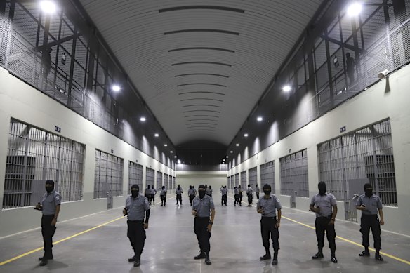 Prison guards stand outside cells at the CECOT prison in 2023.