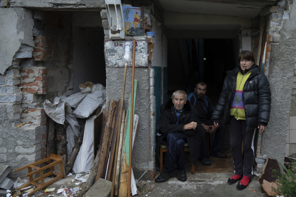 Ukrainian civilians gather at the entrance of their apartment in the recently retaken Izyum.