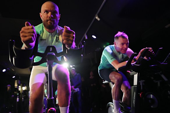 Melbourne captain Max Gawn cycles alongside Tour de France champion Cadel Evans ahead of the Great Ocean Road race.