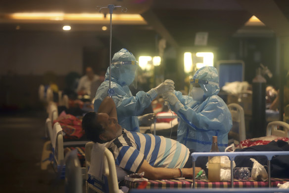 Health workers attend to COVID-19 patients at a makeshift hospital in New Delhi on Friday.