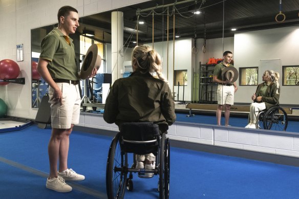 Cyclist Gordon Allan and wheelchair racer Madison de Rozario inspect their uniforms by R.M. Williams. 