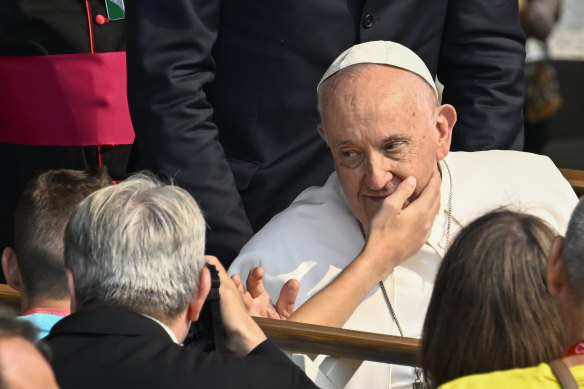 The Pope blesses a pilgrim who touches his face while leaving the Apparitions Chapel at the Sanctuary of Fatima on Saturday.