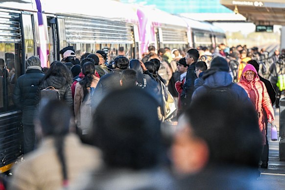 Commuters wait on the platform during the morning peak hour at Tarneit train station.