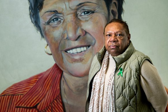 LaVerne Bellear in front of a portrait of Dr Naomi Mayers, the AMS Redfern’s inaugural CEO.