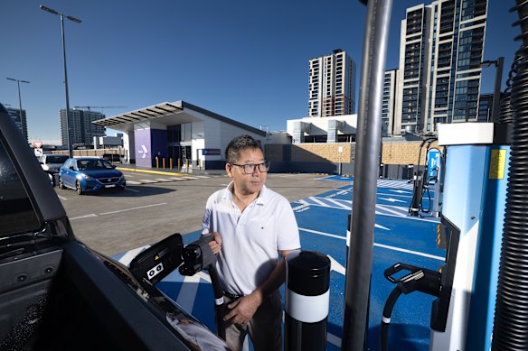 Harry Li, who runs a shopfitting business in Lansvale, charges his BYD Shark at an EV charging station at Merrylands. Parts of Sydney are lagging in charging infrastructure as EV sales boom in the wake of high fuel prices. 