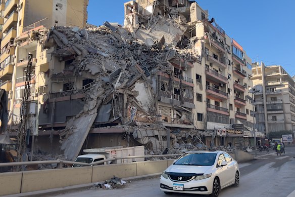 A car passes in front of a destroyed building that was hit by an Israeli airstrike in Dahiyeh, Beirut’s southern suburbs, Lebanon.