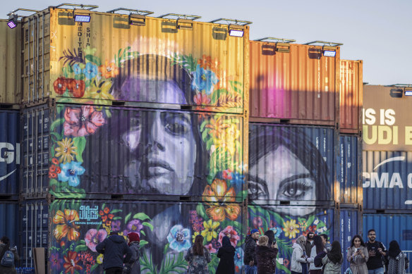 People walk behind a concert stage created from shipping containers and painted by local graffiti artists, during the MDL Beast Festival, a three-day musical extravaganza designed to change perceptions of the Kingdom.  