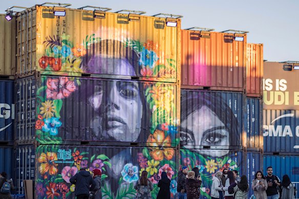 People walk behind a concert stage created from shipping containers and painted by local graffiti artists, during the MDL Beast Festival, a three-day musical extravaganza designed to change perceptions of the Kingdom.  