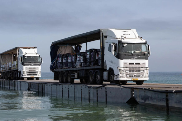 Trucks loaded with humanitarian aid from the United Arab Emirates and the United States Agency for International Development cross the Trident Pier before entering the beach in Gaza. Much of it did not reach its destination.