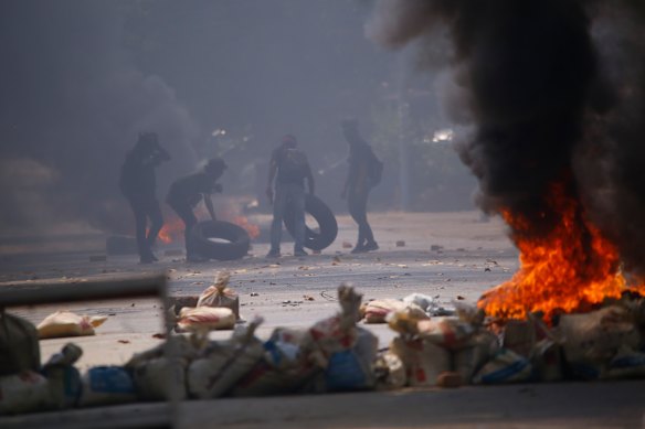 Protesters gather tyres to add to fires started during a rally against the military coup in March 2021.