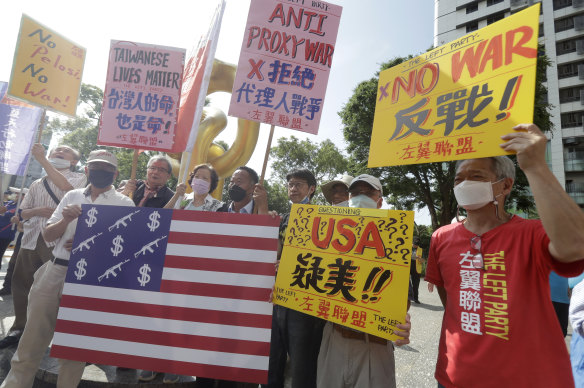 Protesters shout and hold posters against a “proxy war” outside the Taiwan-US Defence Industry Forum in Taipei on Wednesday.